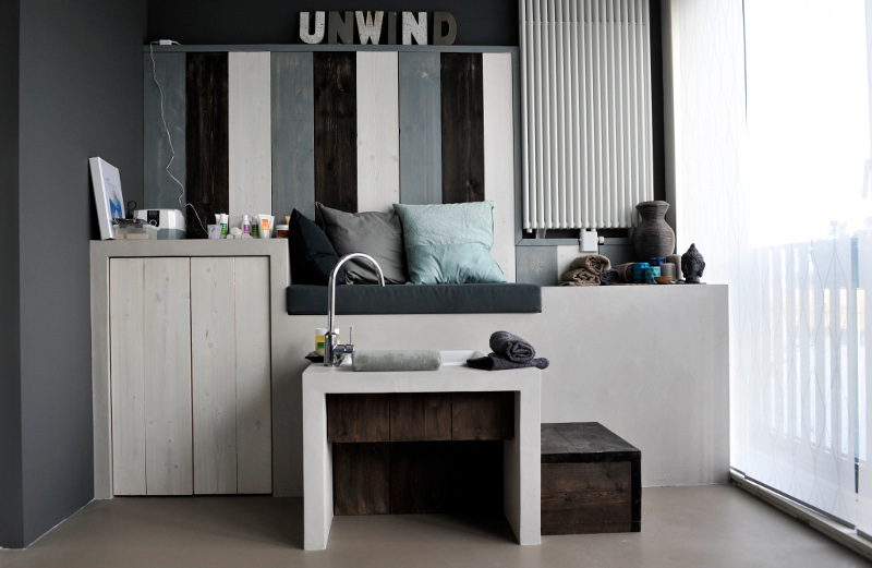 Voetenbad met kraan in de studio, met de letters UNWIND op de wand